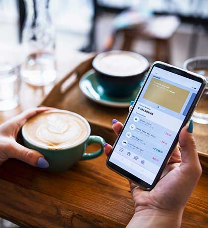 Woman holding phone and coffee