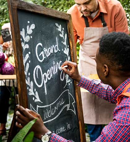 Man writing grand opening on sign