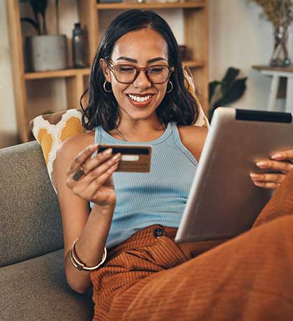 Woman using tablet holding credit card